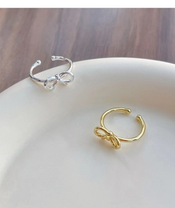 Close-up of elegant S925 sterling silver bow rings in gold and silver finishes