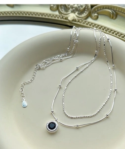 Detailed macro view of S925 sterling silver layered necklace with black onyx pendant