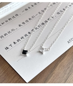Macro detail of square zircon pendants in black and white with S925 silver chain