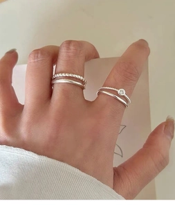 Close-up of minimalist S925 sterling silver stacked rings with a single zircon stone