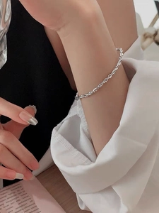 Detailed view of an S925 sterling silver twisted rope bracelet worn on a woman's wrist