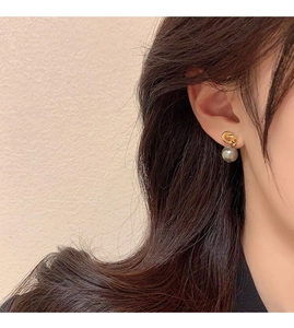 Detailed view of silver knot earrings with grey pearls on model showing elegant drape
