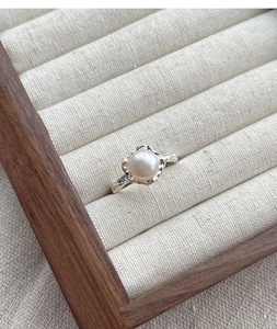 Dettaglio ravvicinato dell'anello in argento S925 con texture irregolare e perla naturale