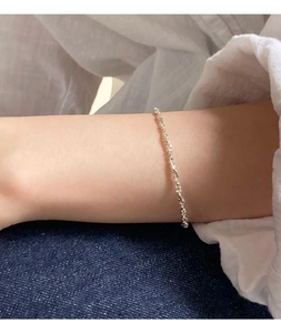 Detail of a minimalist S925 sterling silver twisted rope bracelet worn on a wrist