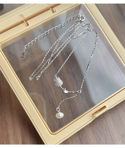 Detail of S925 silver tulip pendant necklace with micro-pave crystals and drop pearl charm