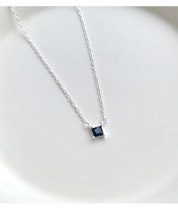 Detailed macro view of black square zircon pendant with silver four-prong setting