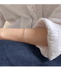Close-up of a minimalist S925 sterling silver beaded bracelet on a woman's wrist