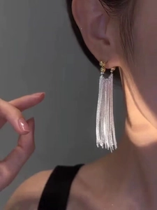 Gros plan de boucles d'oreilles pendantes en argent S925 avec pampilles et perle dorée sur mannequin