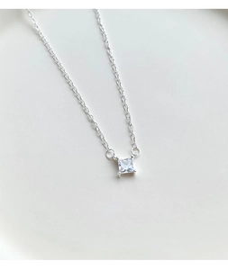Macro shot of minimalist S925 silver necklace with square cubic zirconia pendant