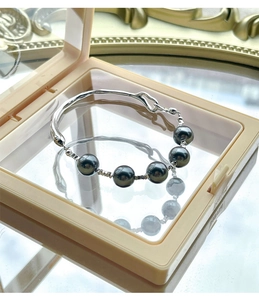 Close-up of S925 silver irregular bangle featuring five lustrous dark gray pearls