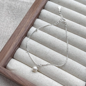 Elegant S925 sterling silver chain bracelet with a single freshwater pearl on display