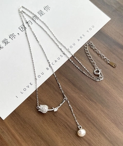 Detail of S925 silver tulip pendant with elegant freshwater pearl on a delicate chain