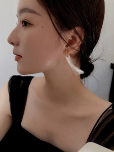 Gros plan de boucles d'oreilles S925 en argent à pompons avec maille courbe texturée