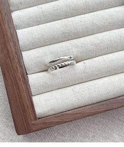 Detail of silver double layer chain rings on a jewelry tray with polished finish