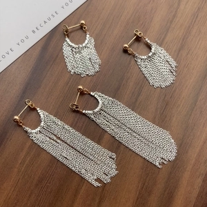 Élégantes boucles d'oreilles S925 à franges argentées et crochets dorés sur fond de bois