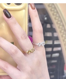 Detailed view of S925 silver bow rings in gold and silver finishes on a finger