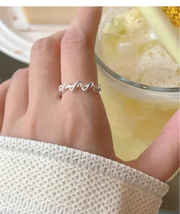 Detailed close-up of woven double-line silver ring with textured and polished finish