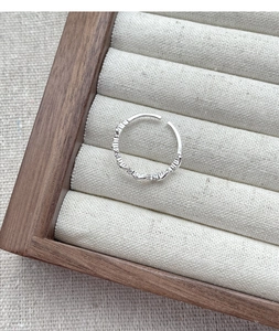 Close-up of minimalist S925 sterling silver braided ring on jewelry display
