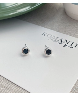 Macro shot of S925 silver stud earrings with black onyx and rope textured borders