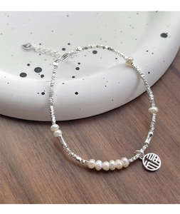 Detailed macro view of S925 silver beaded bracelet with pearls and a Fu character charm