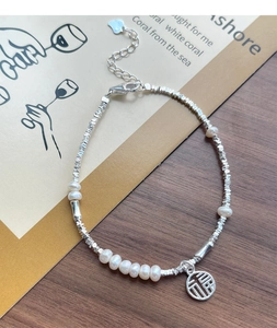 Detail of S925 silver bracelet with irregular beads, white pearls and Fu character charm