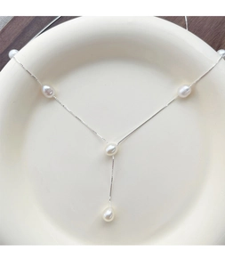 Detail of S925 silver Y-shaped necklace with five lustrous freshwater pearls on ceramic