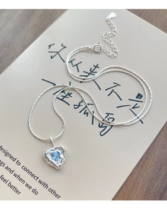 Macro detail of S925 silver heart necklace with blue zircon and lava texture