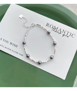 Detail of S925 silver bracelet with crushed silver beads and dark grey pearls on card