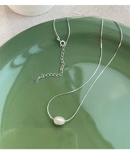 Dettaglio della collana in argento S925 con perla d'acqua dolce su vassoio ceramico