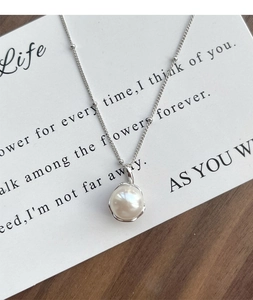 Detail of S925 silver necklace featuring a freshwater pearl in an irregular metal frame