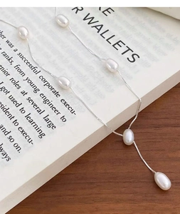 Macro detail of S925 sterling silver chain with elegant white oval freshwater pearls