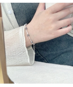 Detail of S925 silver bracelet with five grey pearls worn on wrist for daily styling