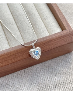 Macro shot of S925 silver heart necklace with blue zircon and irregular lava texture