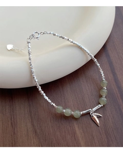 Detailed macro view of S925 silver beaded bracelet with green jade beads and leaf charm