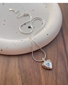 Detail of S925 silver heart necklace showing irregular texture and blue zircon stone
