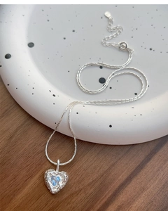 Detailed close-up of S925 silver heart pendant with blue zircon on a minimalist tray