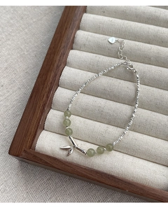 Close-up of S925 sterling silver bamboo pendant with light green jade beads