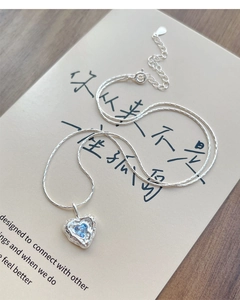 Close-up of S925 silver heart necklace with blue zircon and lava texture detail