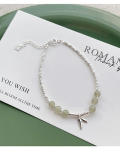 Macro shot of S925 sterling silver bamboo leaf charm and green jade beads on bracelet
