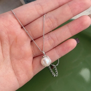 Elegant S925 sterling silver necklace featuring a single round freshwater pearl pendant