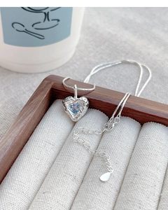 Macro detail of S925 sterling silver heart necklace with irregular texture and blue zircon