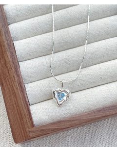 Detailed close-up of S925 sterling silver heart necklace with blue zircon and irregular texture