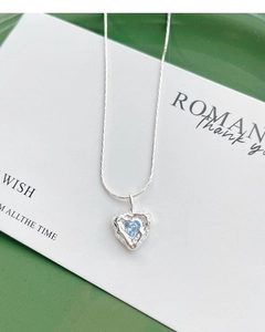 Detailed macro shot of S925 silver heart necklace with blue zircon and irregular texture