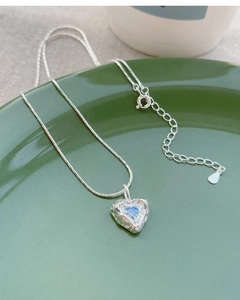 Detail of S925 silver heart necklace showing textured metal and blue zircon stone