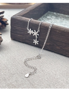 Macro detail of S925 sterling silver snowflake necklace with cubic zirconia on wood box