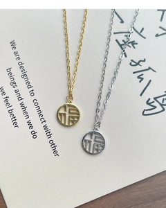 Detailed view of gold and silver S925 sterling silver Fu pendant necklaces on gift cards