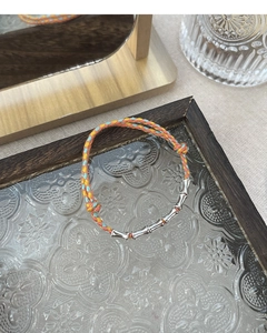 Detail of woven colorful bracelet with S925 silver bamboo joints on floral glass