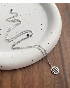 Macro detail of S925 silver necklace featuring a hollow Fu character pendant on a tray