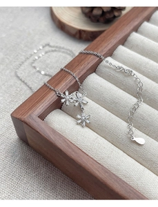 Detail of S925 sterling silver snowflake pendant necklace with cubic zirconia on wood