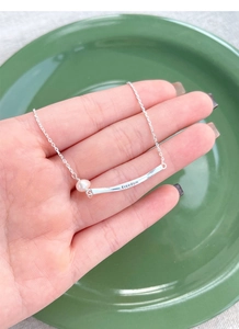 Detail of S925 silver necklace with white freshwater pearl and Freedom engraved bar